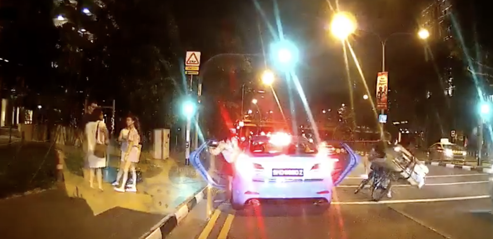 Taxi stops at red light near pedestrian crossing, passenger opens door