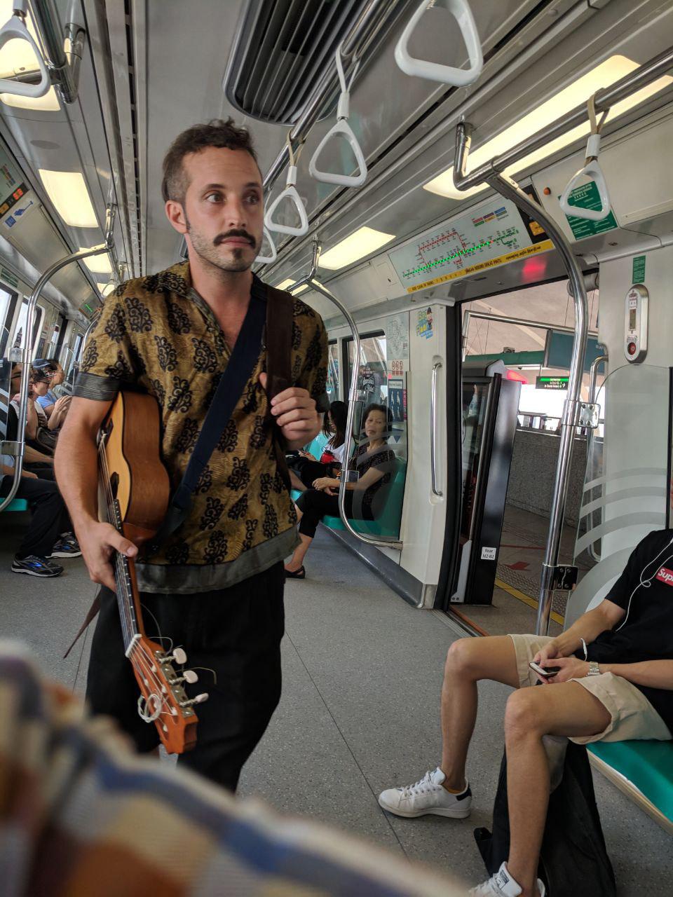 Begpackers spotted on S'pore East-West Line MRT performing ...