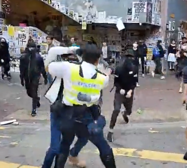 hong kong protests police grabbing a protester and aiming a gun at another