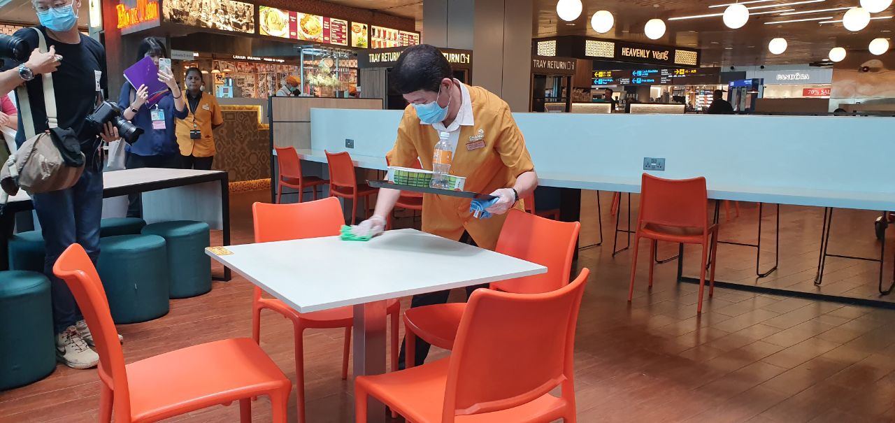 Airport cleaner cleaning cafeteria table