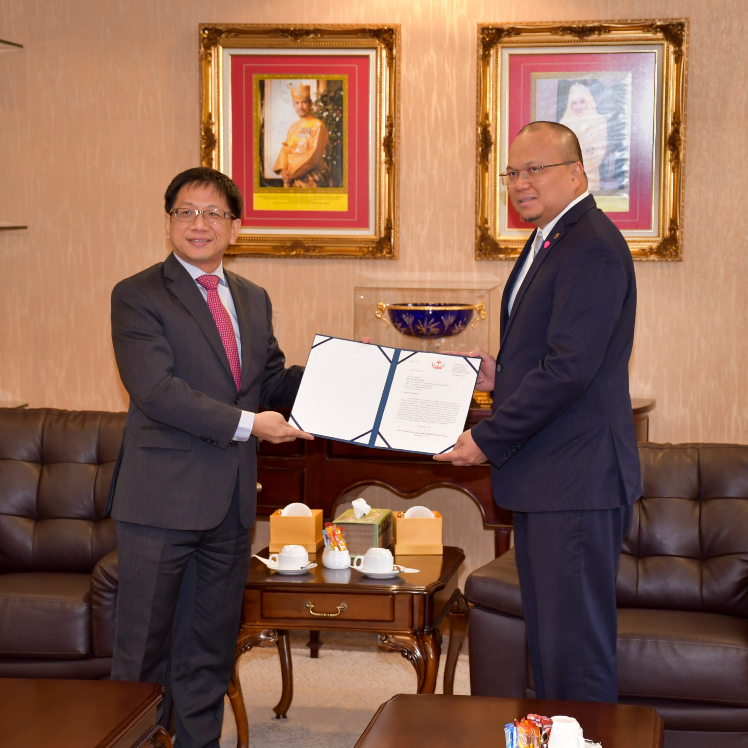 Singapore High Commissioner to Brunei Darussalam Lim Hong Huai (left) receiving a letter of appreciation from Brunei Minister of Health Dato Seri Setia Dr Haji Mohammad Isham bin Haji Jaafar (right) for Singapore’s contribution of COVID-19 diagnostic tests to Brunei.