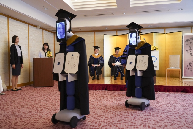 Students receiving their certificates from the president via the newme robots