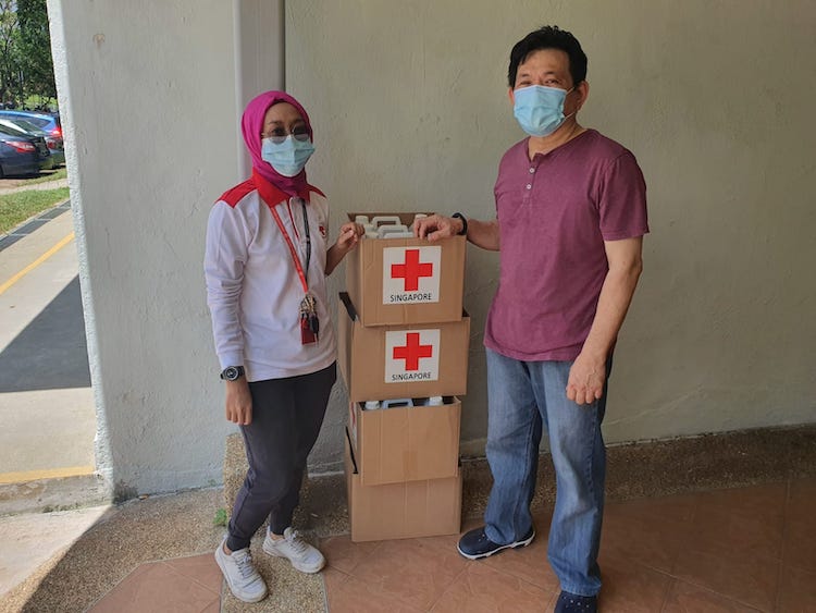 photo of Red Cross donating masks and sanitisers