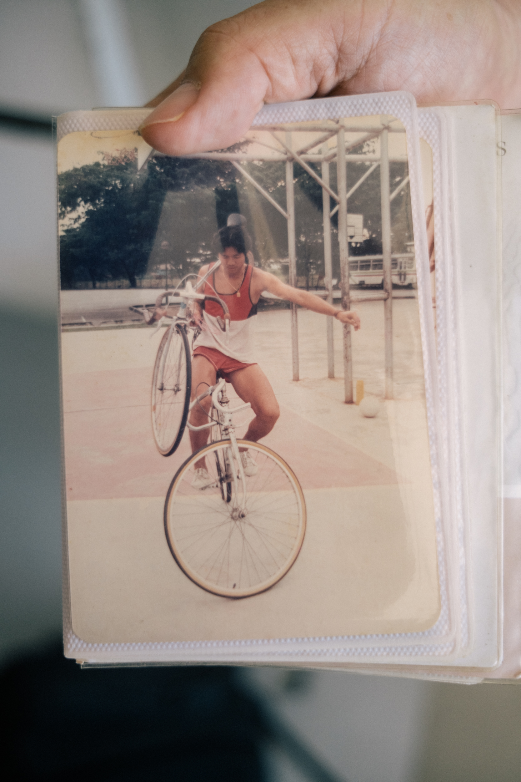 Image of Henry Leong cycling while carrying another bicycle