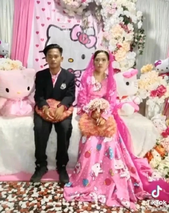 Bride and groom in pink Hello Kitty wedding attire