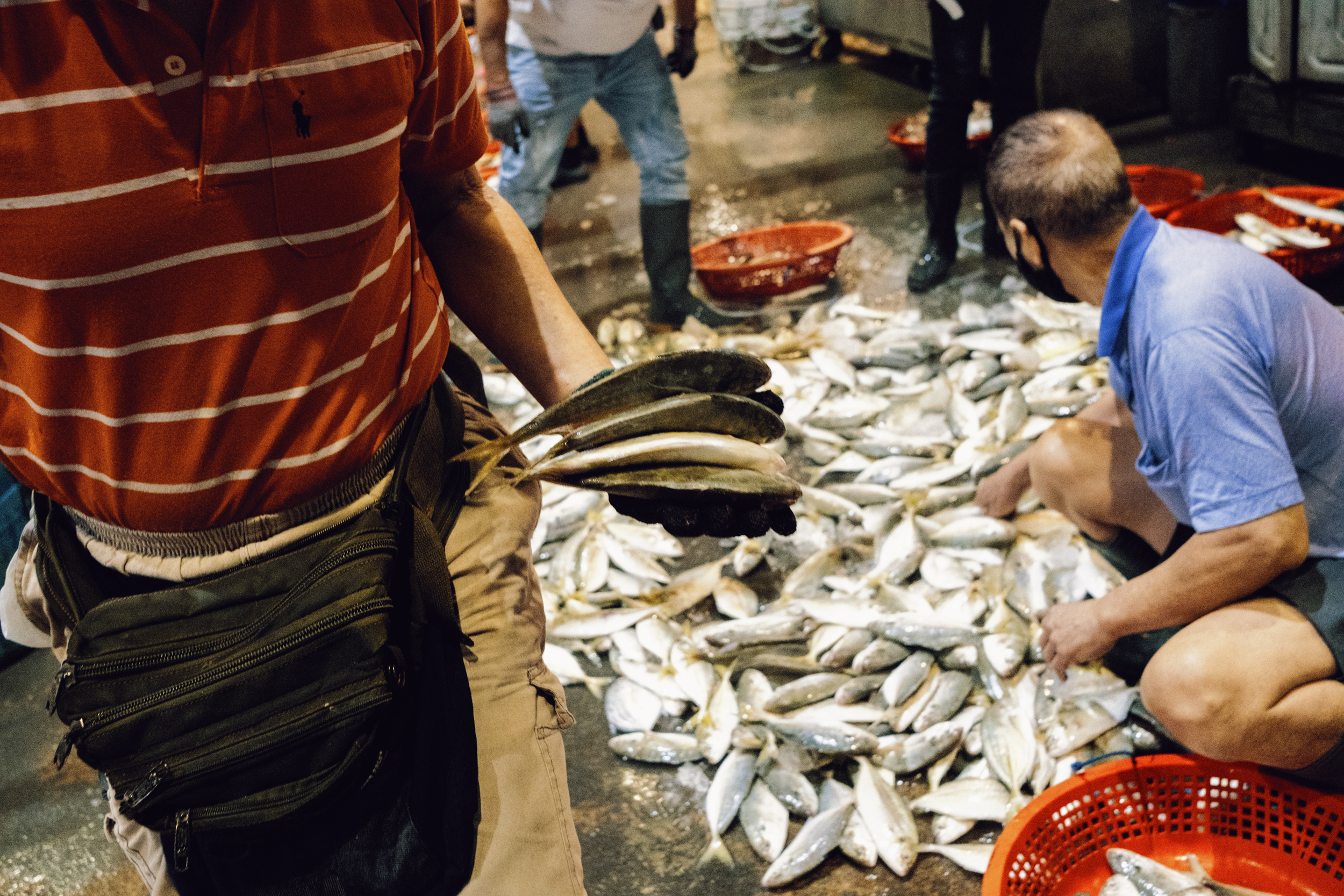 Customers bring fish to be weighed.