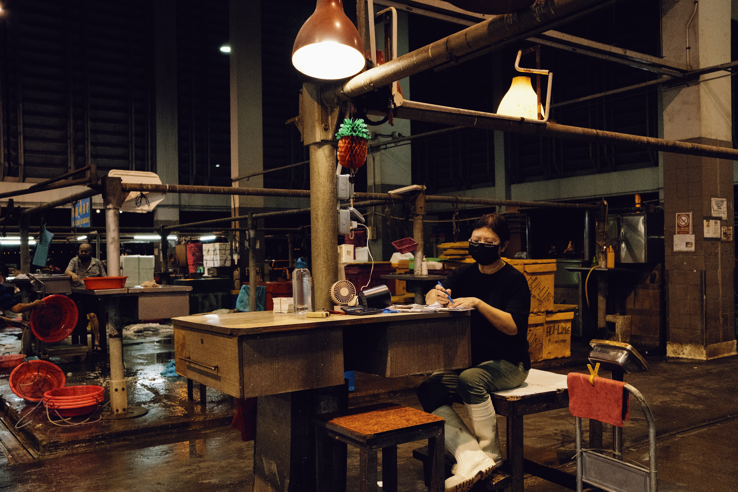 A fisher wholesaler works in the quiet before the market opens.