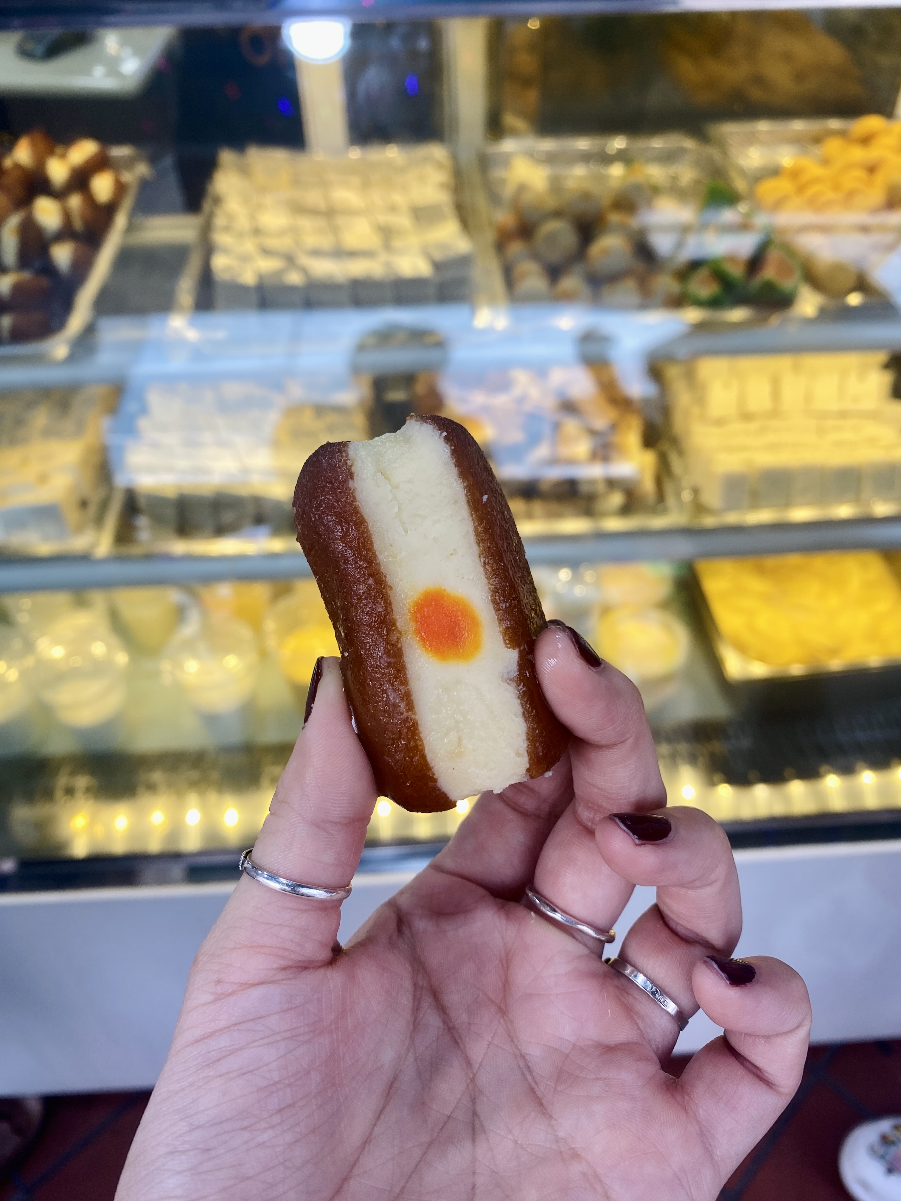 image of a brown and white oval snack taken against a background of a sweet shop