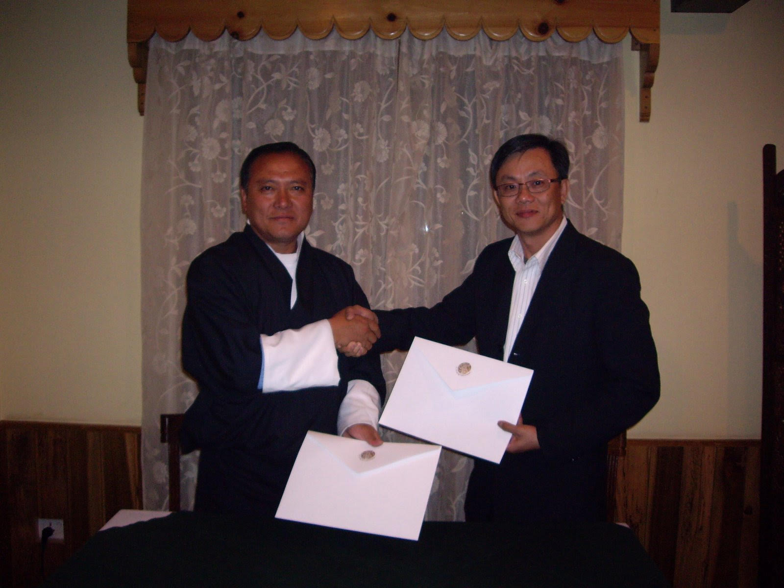 Ng Hua Chong signing documents with officials in Bhutan.