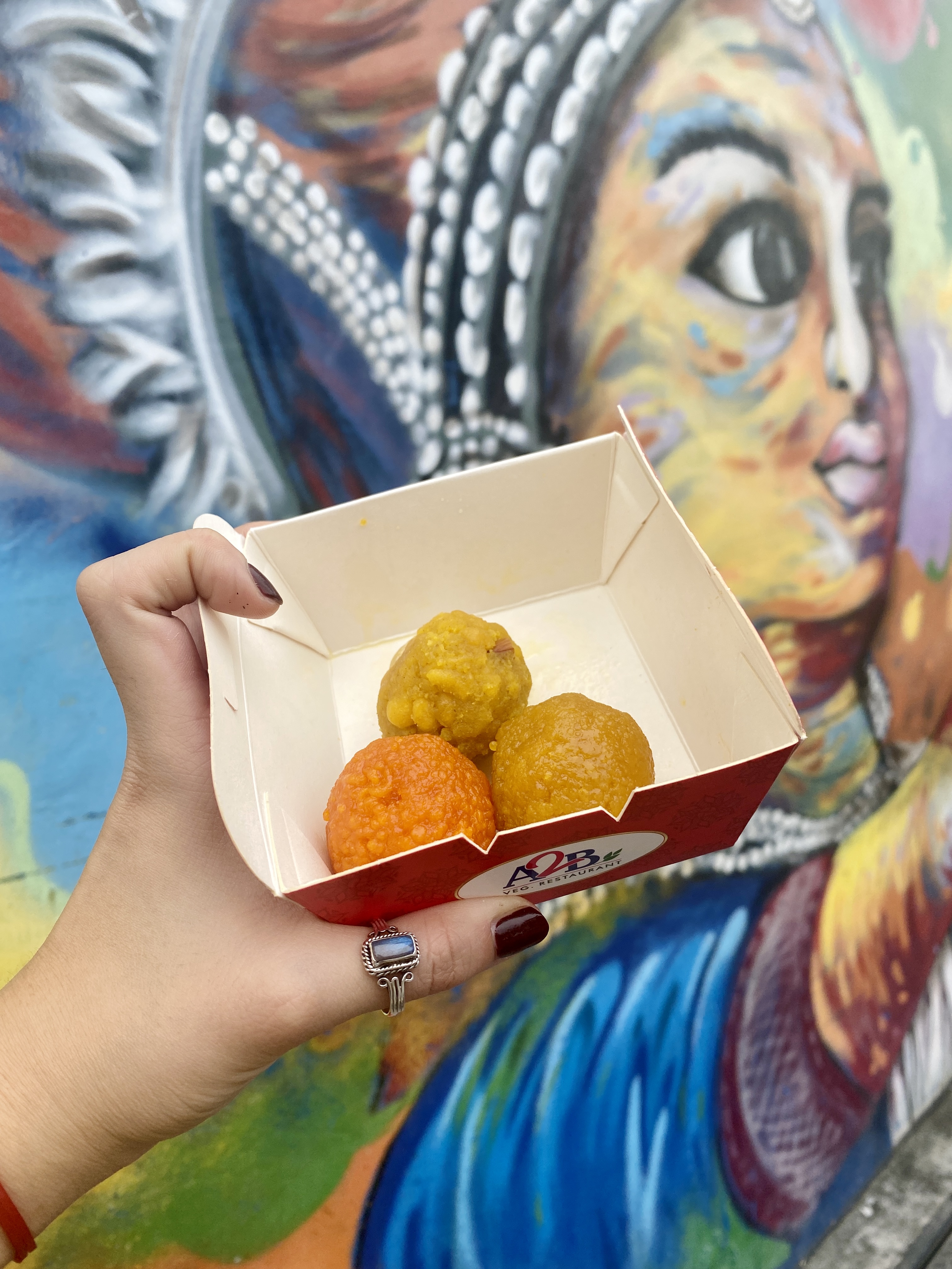 image of 3 yellow and orange spherical snacks against a colorful wall