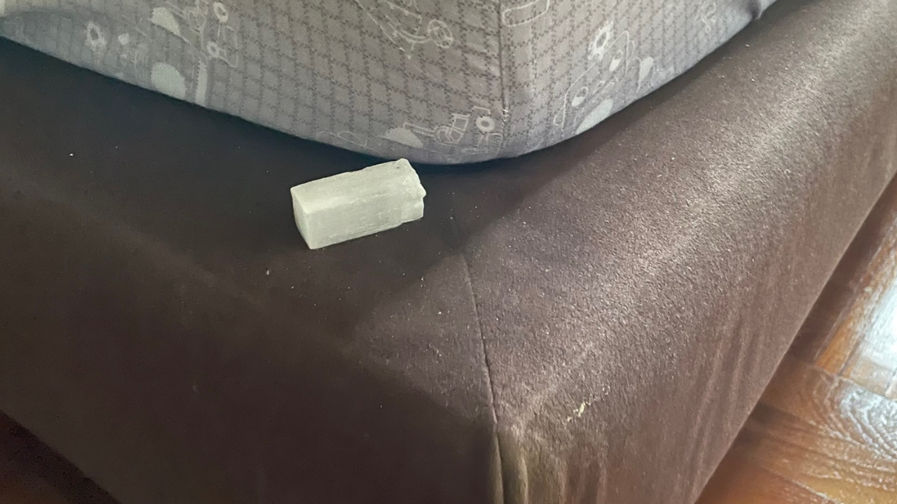 a white crystal (selenite), placed on the corner of a bed