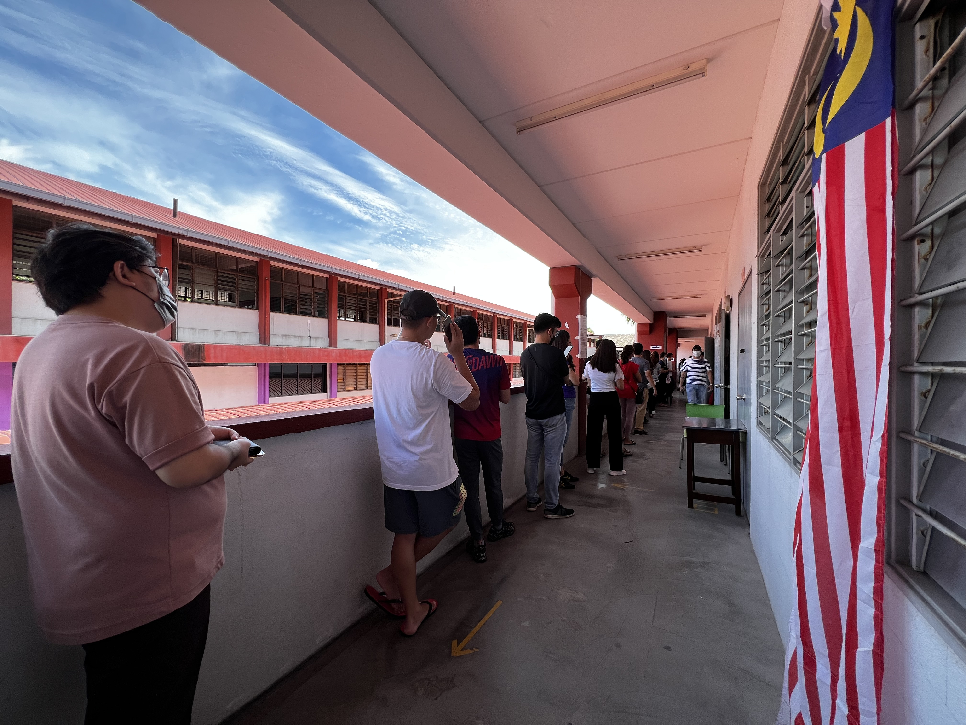 Voters queue up at a school to cast their ballot