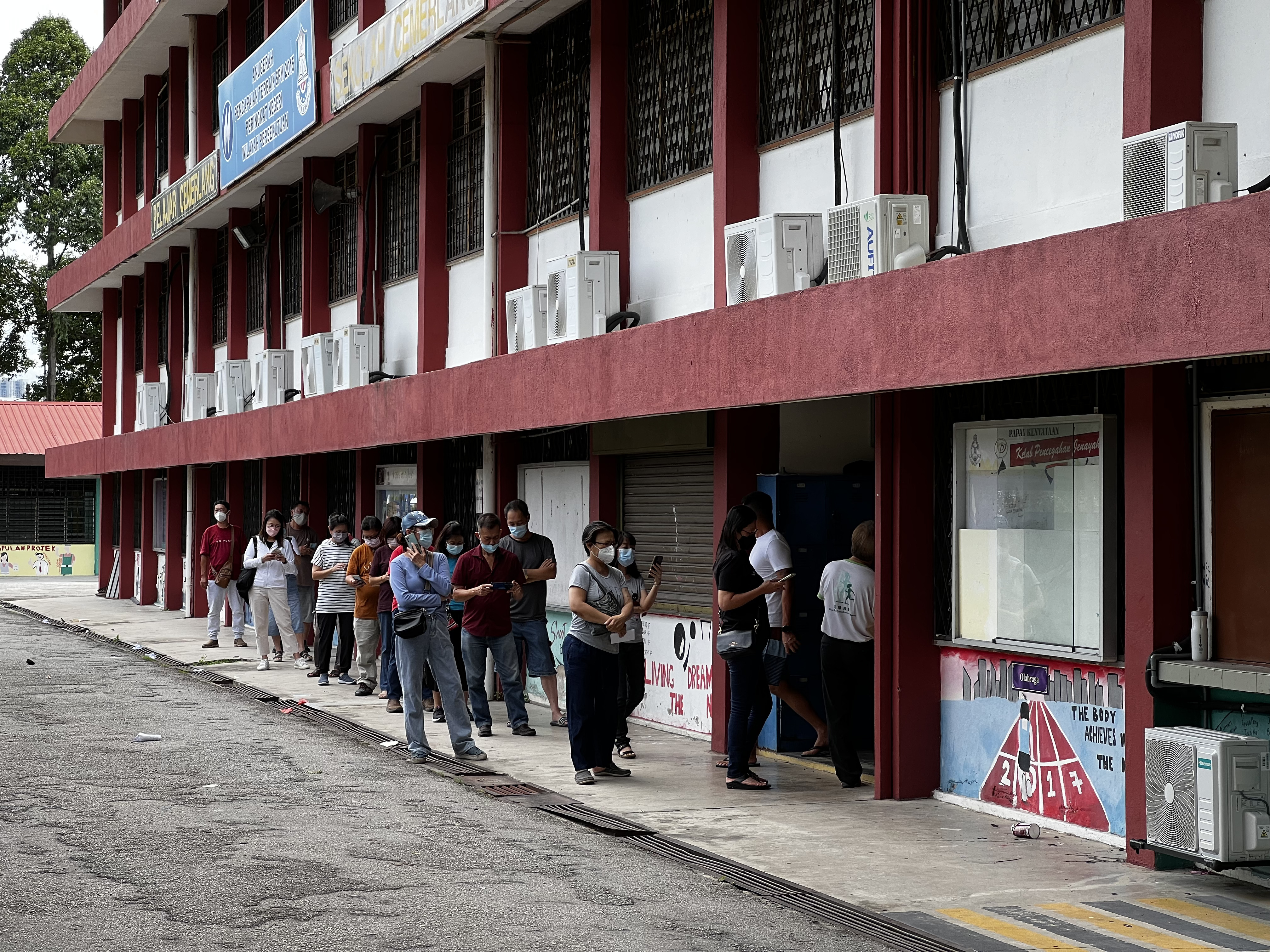 Voters queue up at a school to cast their ballot