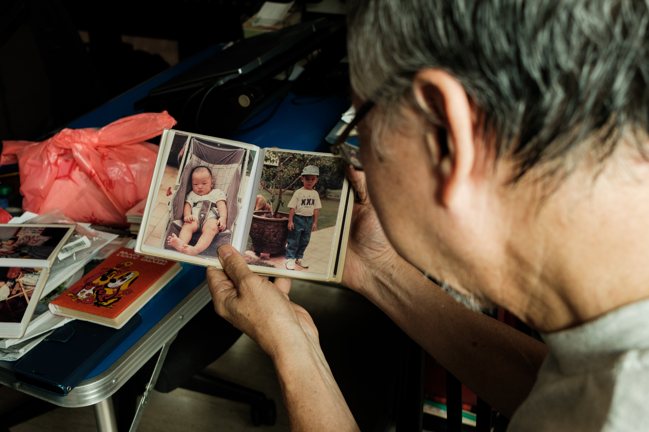 Ong's father looking at old photos of his son