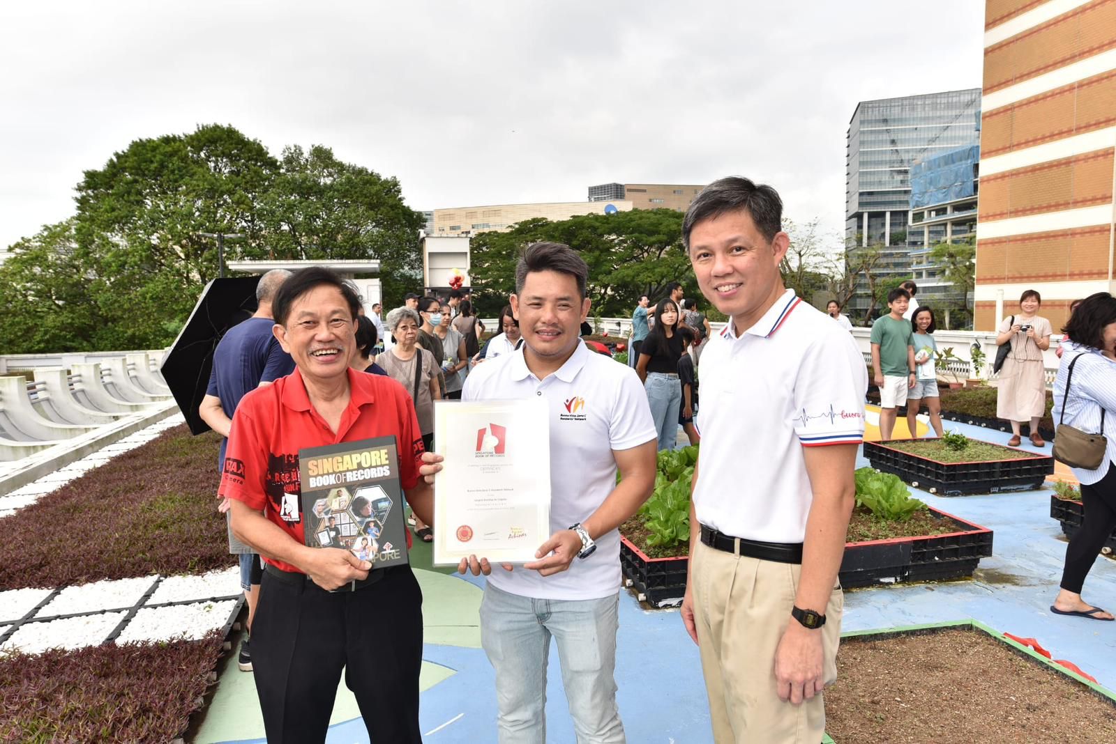 Presentation of the certificate to Chan Chun Sing and community volunteers