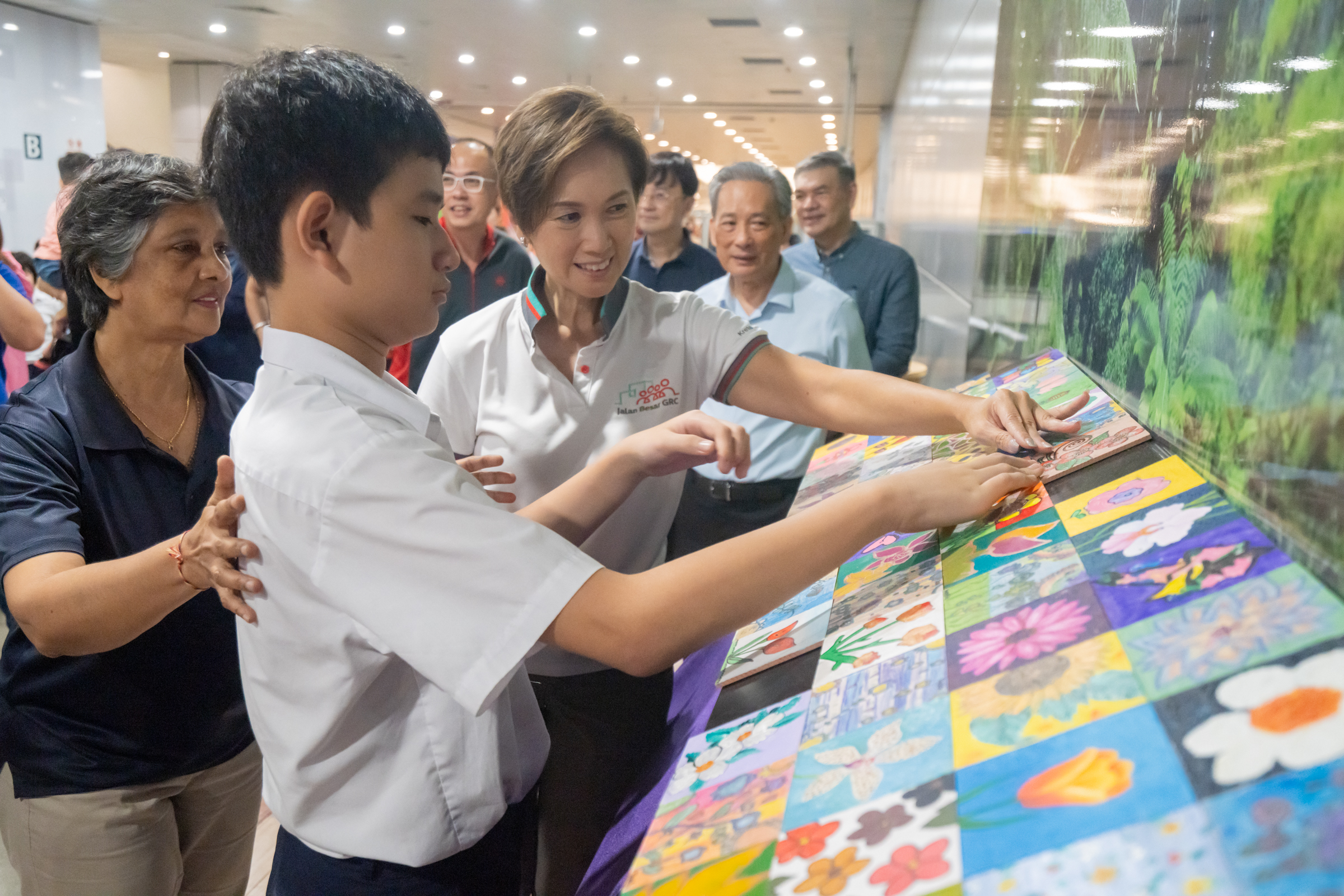 Minister Josephine Teo Mounting Decorative Artwork with Student at SMRT's Music in Community Launch Event