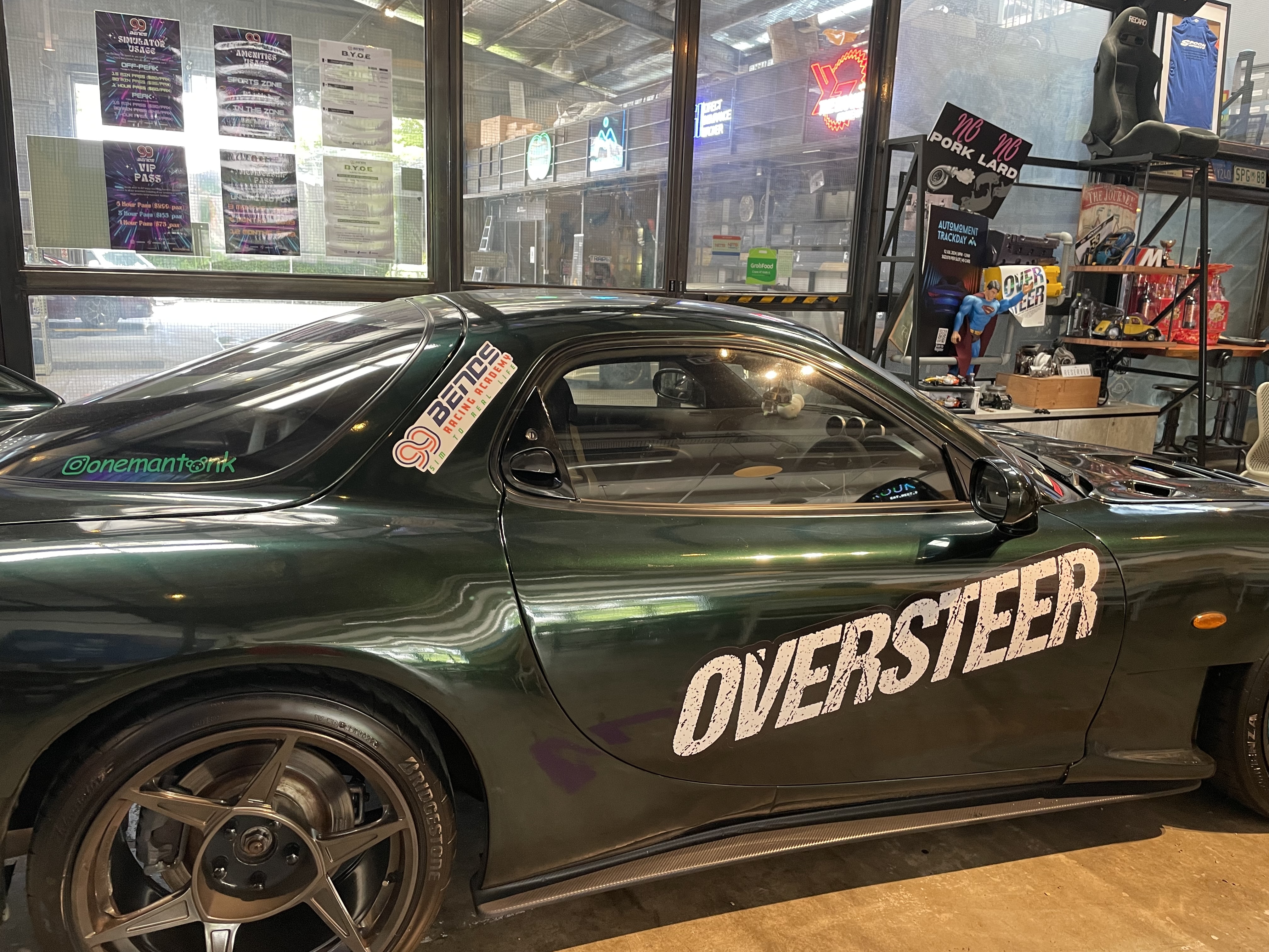 A green sports car inside Rounding with an Oversteer decal on its side.