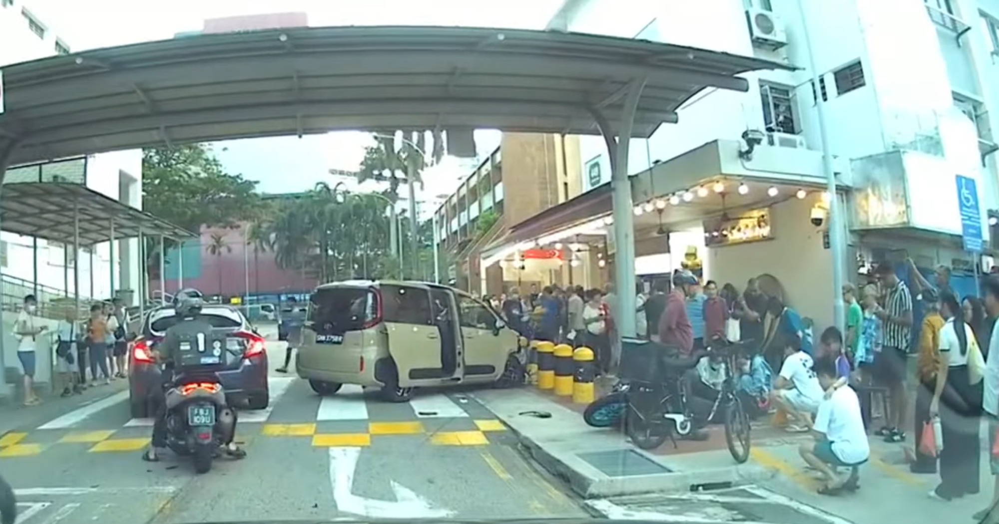 Woman, 83, allegedly crashes car into motorcyclist & bollards outside Clementi coffee shop
