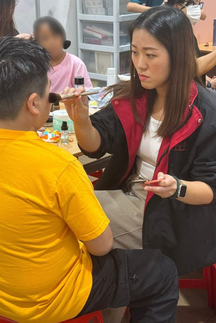 Image of Tan applying make up to a child.
